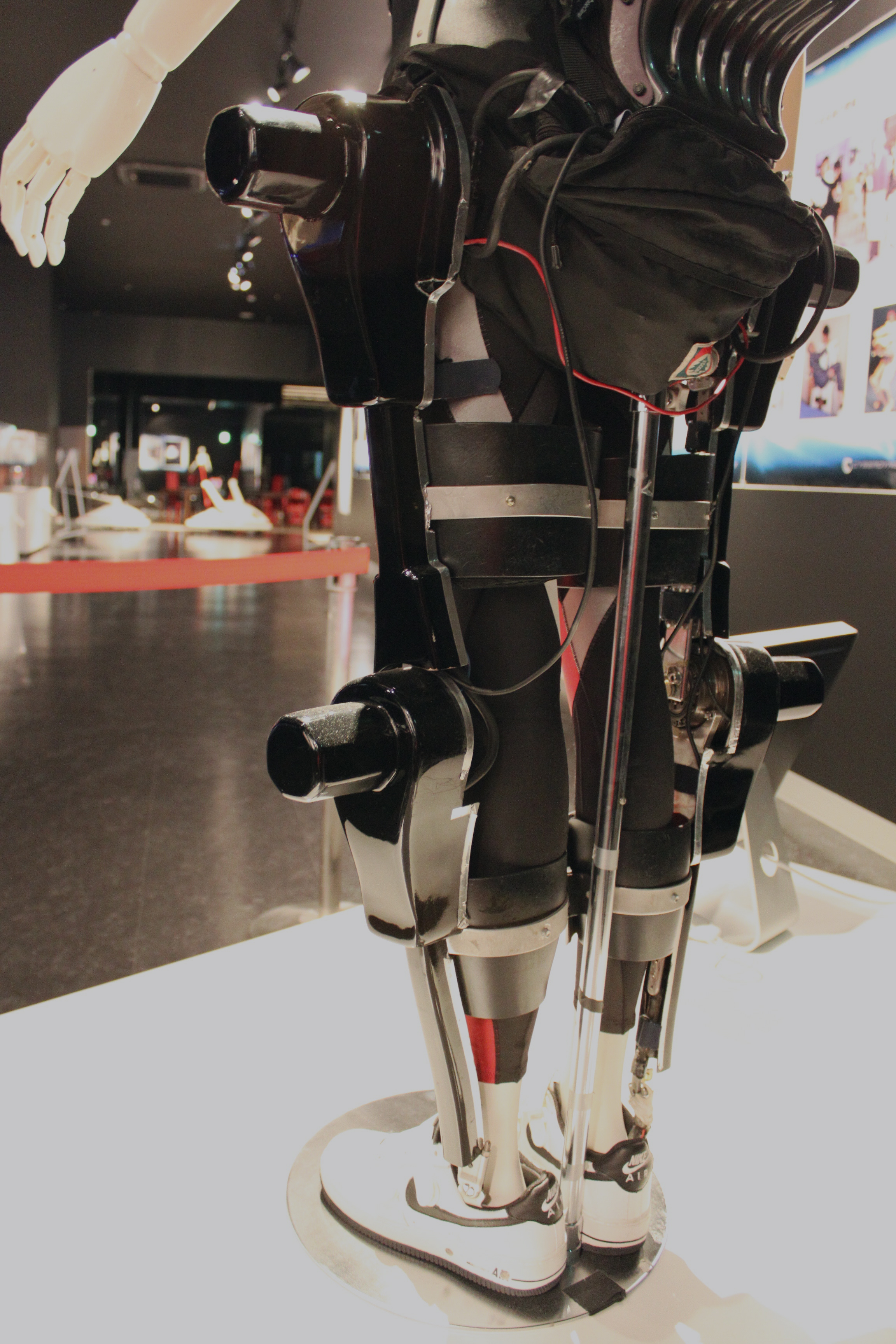 A person wearing the Hybrid Assistive Limb powered exoskeleton, with rigid supports along the legs and actuators at the hip and knee joints.