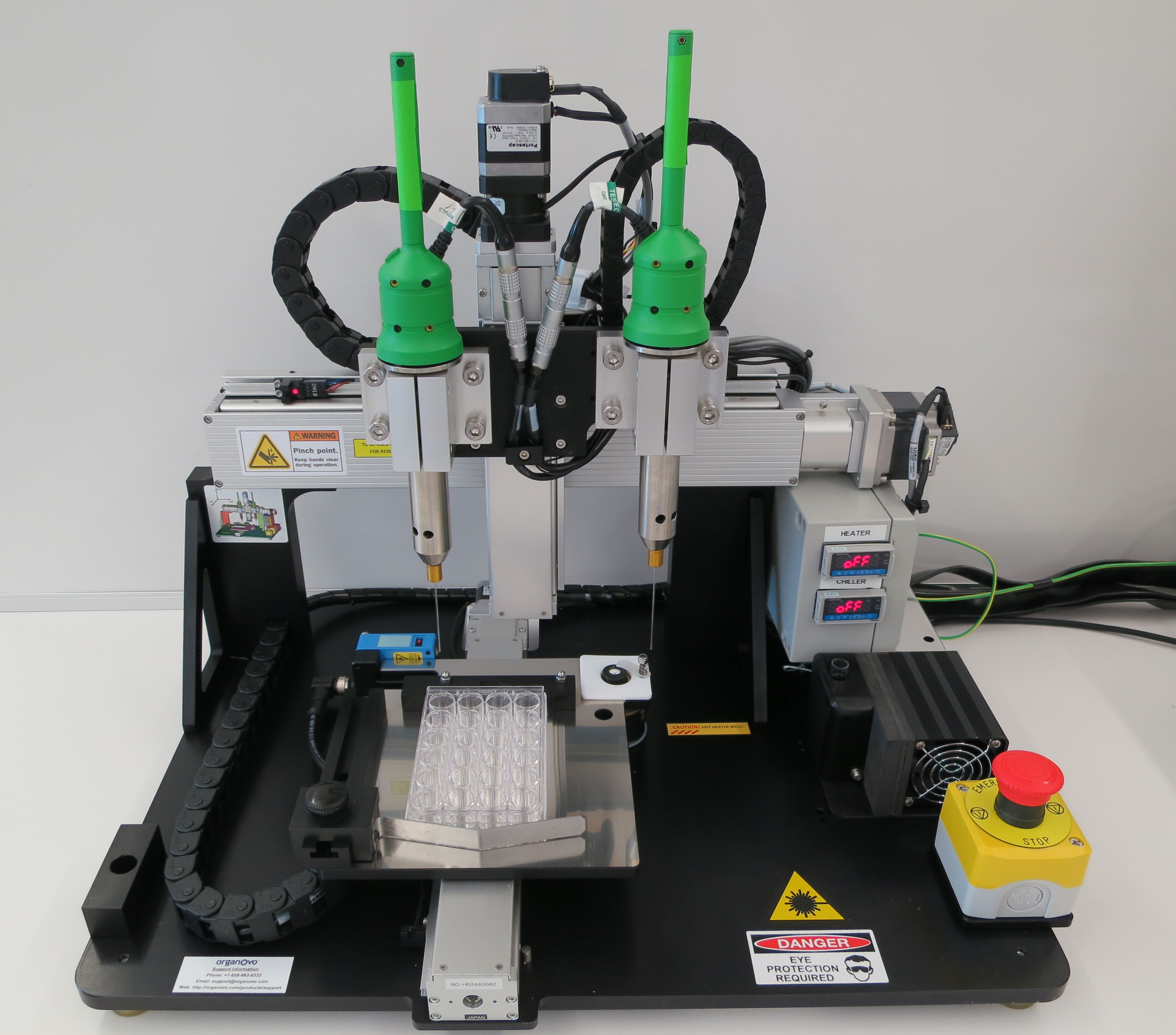 A laboratory bioprinter, an enclosed instrument with a moving print head positioned above a culture plate.